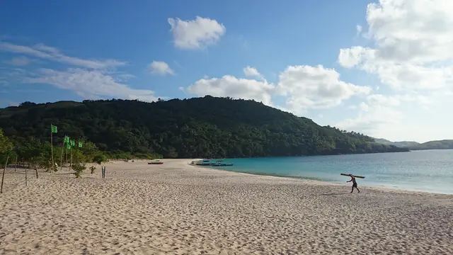 A long white-sand beach and green hills on the Calaguas Islands