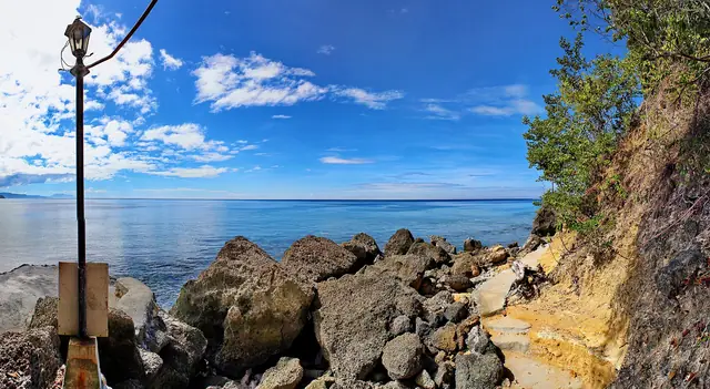 Rocky shore and blue water of Sarangani Bay Protected Seascape