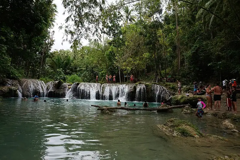 Visitors and rafts on the lower pool of Cambugahay Falls